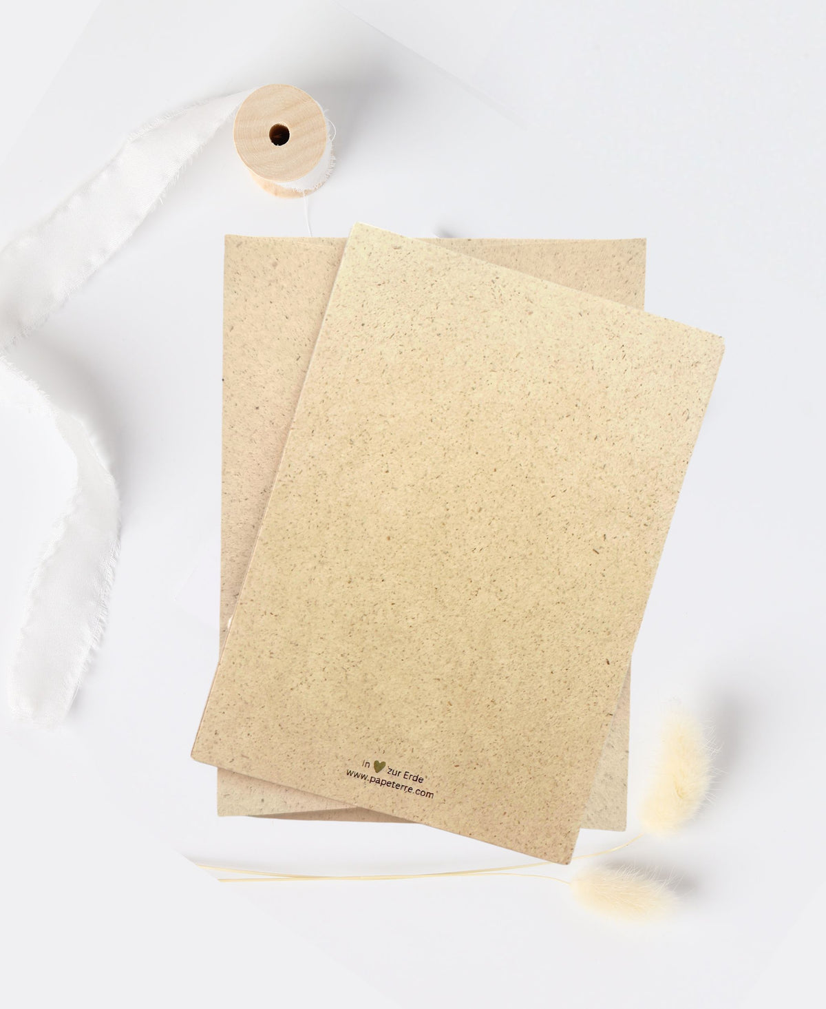 Rückseite einer Graspapierkarte mit dezentem Papeterre-Logo und natürlicher Papierstruktur