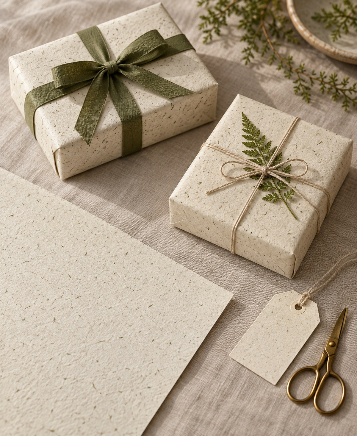 Gestaltungsbeispiel: Geschenke mit blankem A3-Graspapier verpackt, mit olivgrünem Band und Zweig dekoriert; Dekoration nicht enthalten